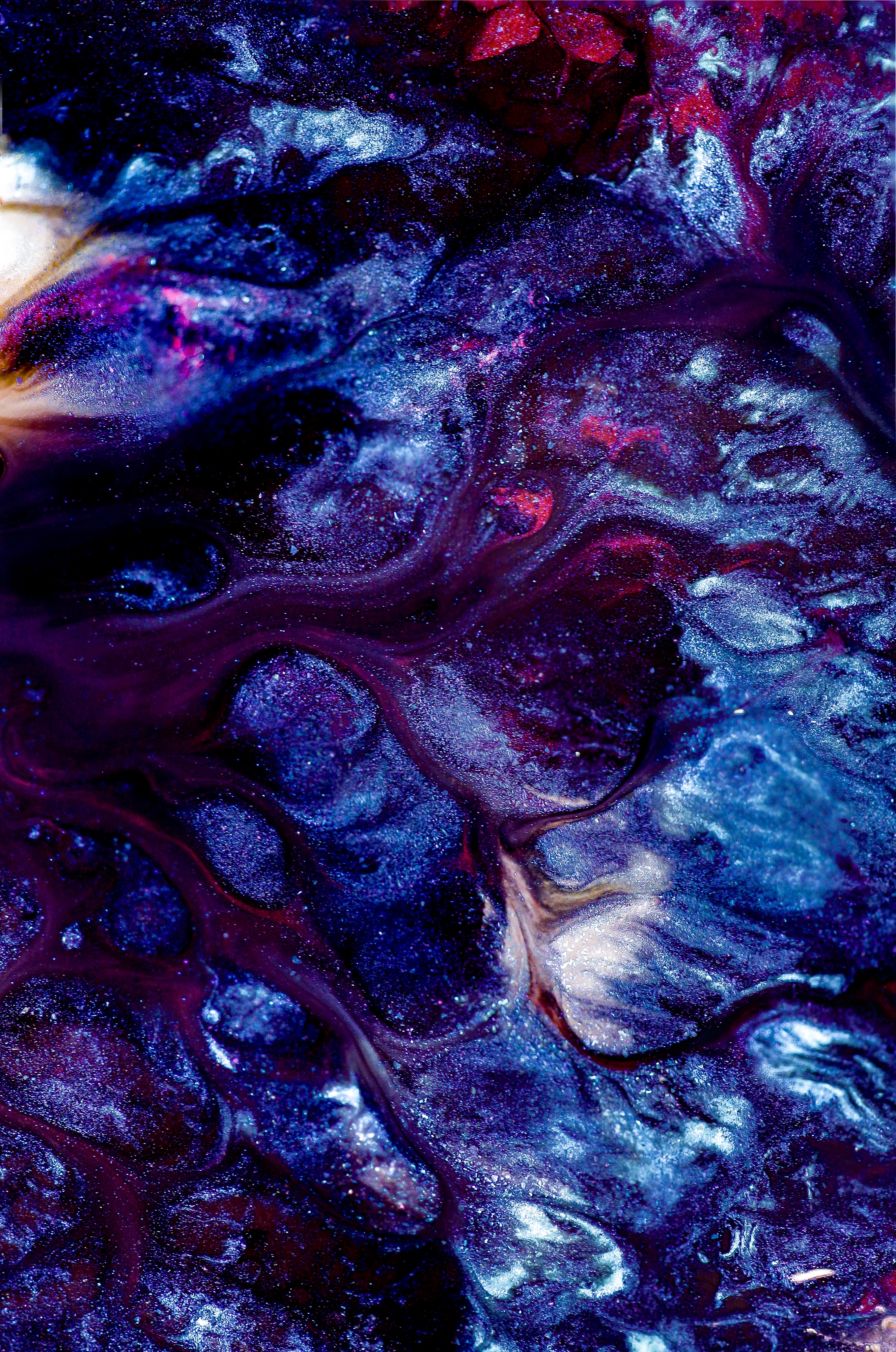 Intuition – Violett und blau glitzernde Farbe, die ineinander fließt