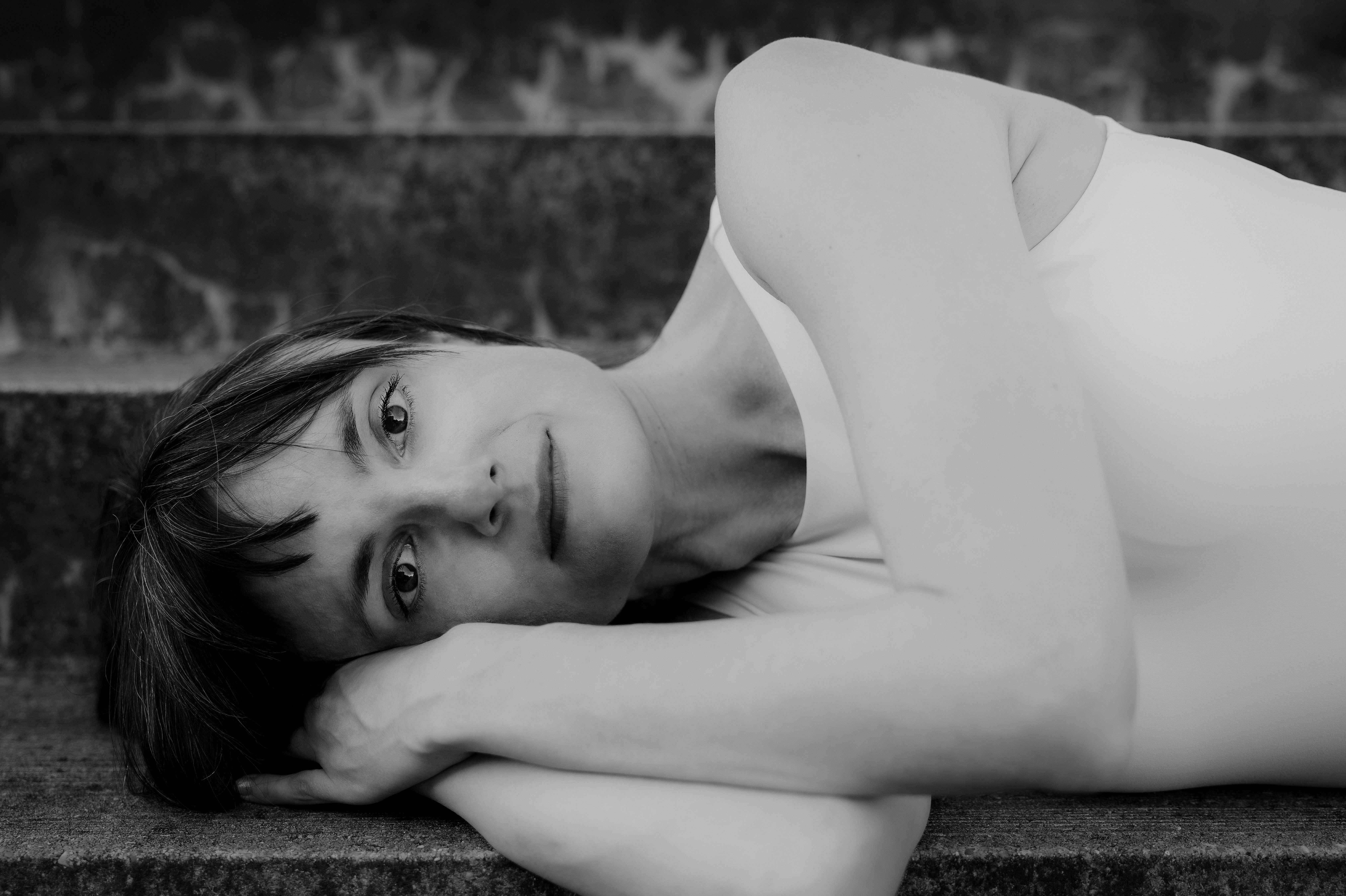 Portrait von Anna seitlich liegend auf Betontreppe