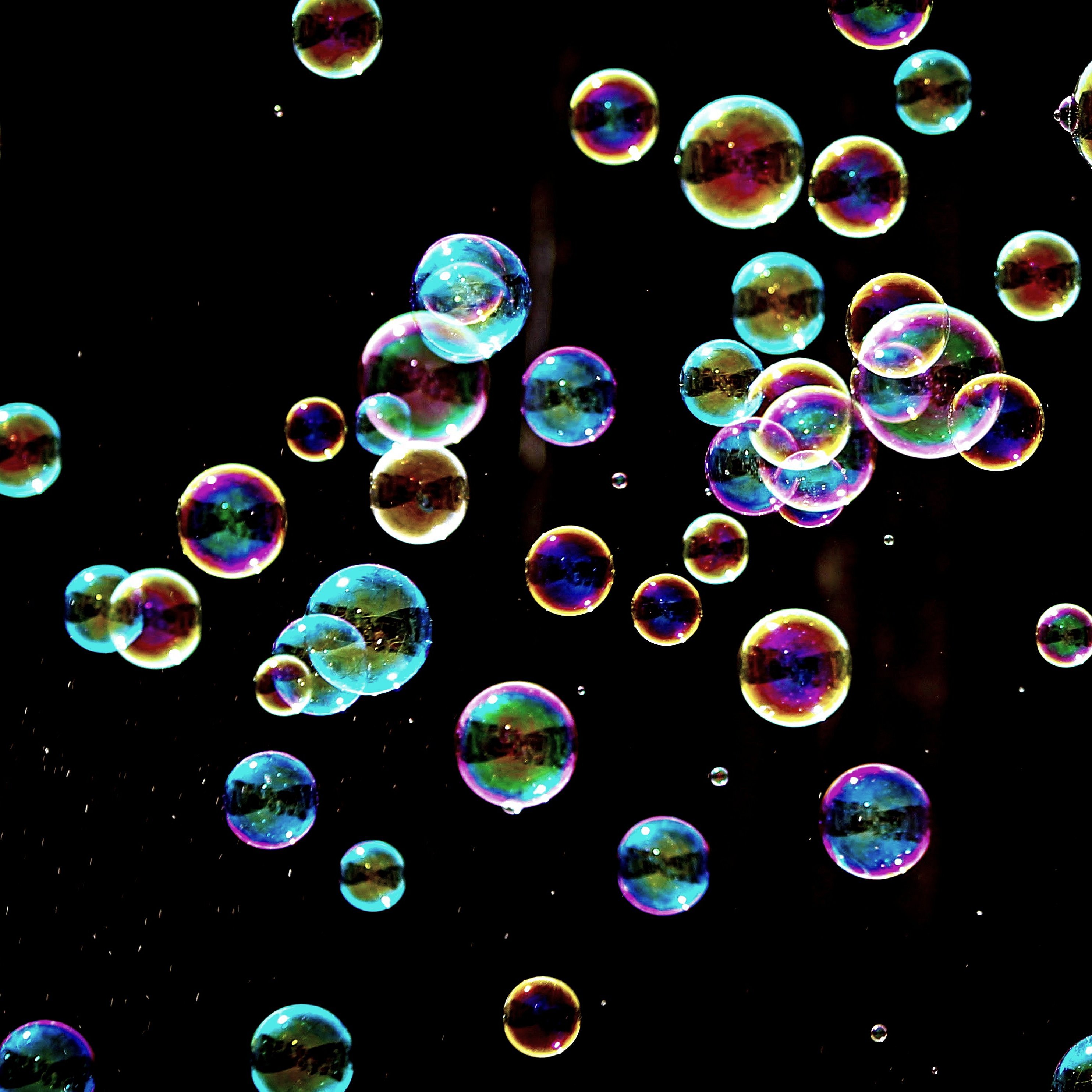 Bunte Seifenblasen vor schwarzem Hintergrund